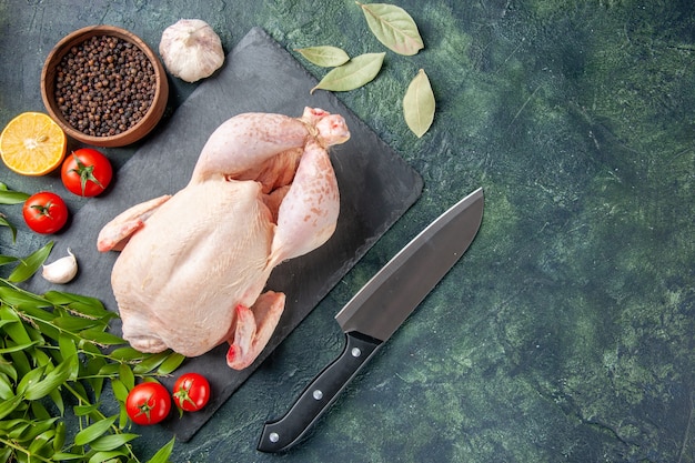 Draufsicht frisches Hähnchen mit Tomaten und Pfeffer auf dunkelblauer Oberfläche