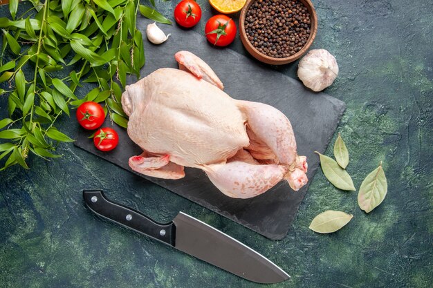 Draufsicht frisches Hähnchen mit Tomaten und Pfeffer auf dunkelblauer Oberfläche