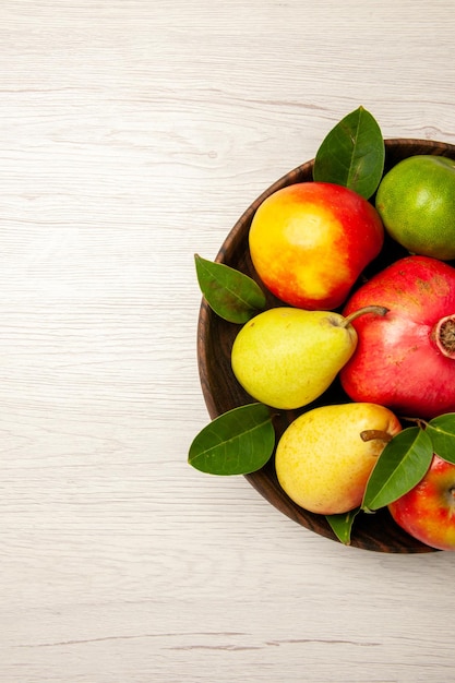 Draufsicht frisches Obst Äpfel Birnen und andere Früchte in der Platte auf weißem Schreibtisch Früchte reifen Baum milden viele frische