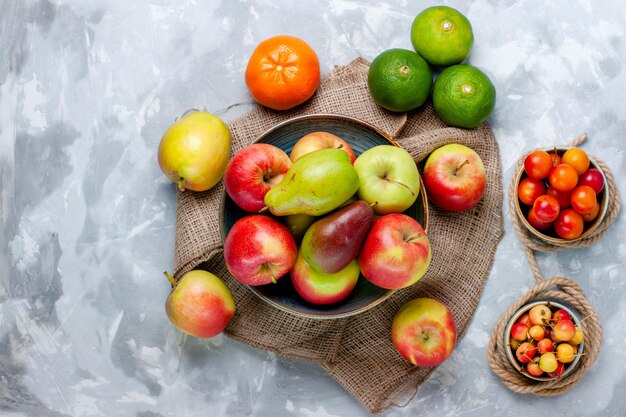 Draufsicht frisches Obst Äpfel und Mango auf dem hellweißen Schreibtisch