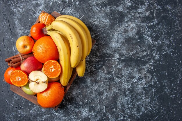 Draufsicht frisches Obst und Zimtstangen auf Holztablett auf dem Tisch mit Kopierraum