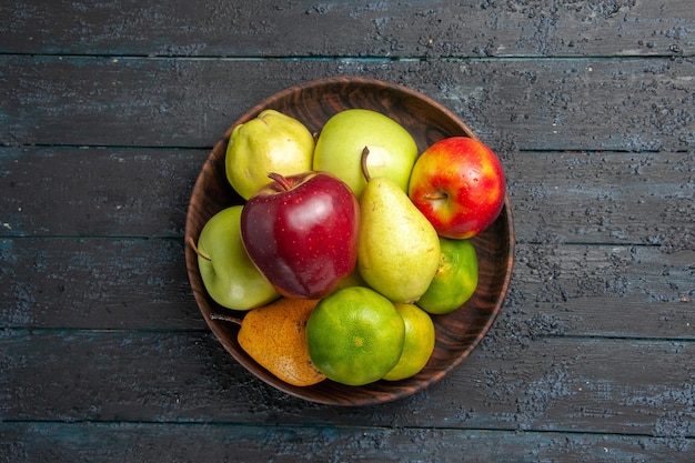 Draufsicht frisches Obst Zusammensetzung Äpfel Birnen und Mandarinen innerhalb des Tellers auf dunkelblauem Schreibtisch Fruchtfarbe frischer reifer weicher Baum