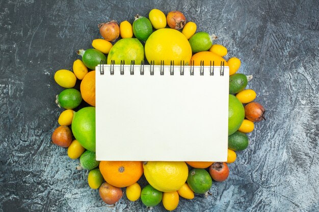 Draufsicht frisches Obst Zusammensetzung Zitronen Feijoa und Mandarinen auf dem grauen Hintergrund