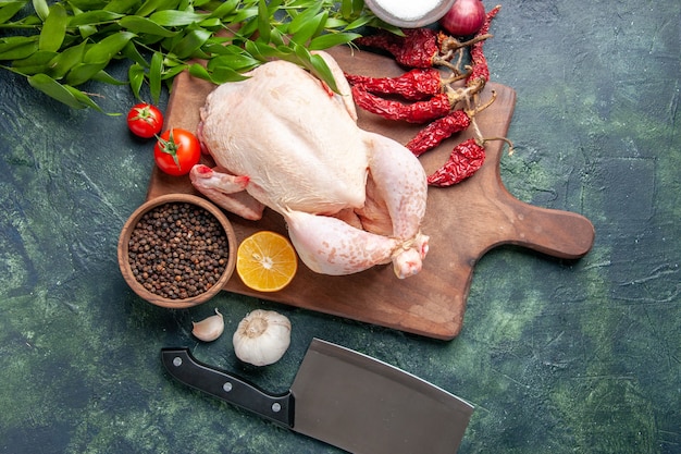 Draufsicht frisches rohes huhn mit roten tomaten auf dunkelblauem hintergrund küchenmahlzeit tierfotofutter hühnerfleischfarbe