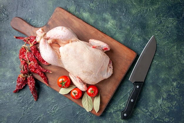 Draufsicht frisches rohes Huhn mit Tomaten auf dunkelblauem Hintergrund Küche Restaurant Mahlzeit Tierfoto Bauernhof Essen Hühnerfleisch Farbe