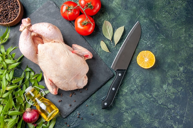 Draufsicht frisches rohes Huhn mit Tomaten auf dunklem Hintergrund Mahlzeit Tierfutter Huhn Küche Fleischfarbe