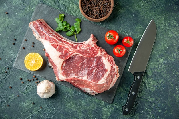 Draufsicht Frischfleischscheibe mit roten Tomaten auf dunkelblauem Hintergrund Küche Tier Kuh Metzger Fleisch Huhn Farbe