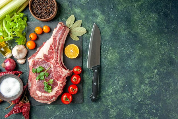 Draufsicht Frischfleischscheibe mit Tomaten auf dunkelblauem Hintergrund Essen Fleisch Küche Tier Metzger Huhn Farbe Kuh Freiraum