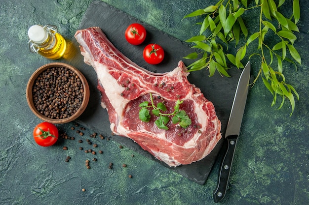Draufsicht Frischfleischscheibe mit Tomaten und Pfeffer auf dunkelblauem Hintergrund Küche Tier Kuh Huhn Lebensmittelfarbe Fleisch