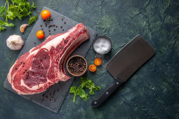 Kostenloses Foto draufsicht frischfleischscheibe rohes fleisch mit pfeffer und grüns auf dunklem hintergrund hühnchenmehl essen tier metzger fotogrill