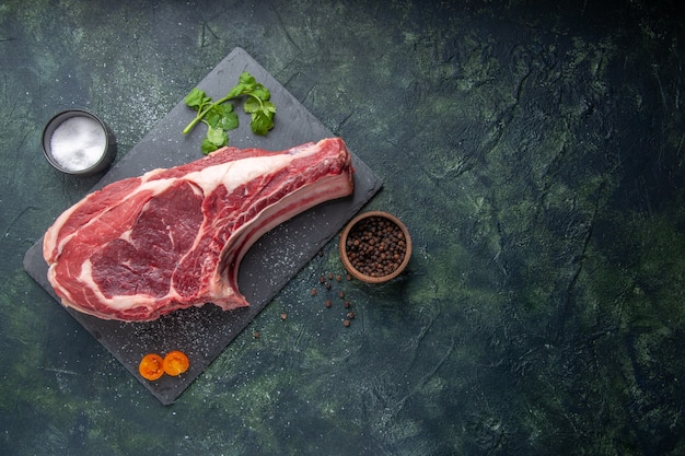 Draufsicht Frischfleischscheibe rohes Fleisch mit Pfeffer und Grüns auf dunklem Hintergrund Hühnermehl Tierfoto Barbecue Essen Metzger