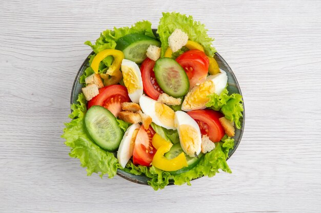 Draufsicht Frischgemüsesalat mit Eiern auf weißem Hintergrund reifes Essen Frühstückssalat Mahlzeit Mittagessen Farbe