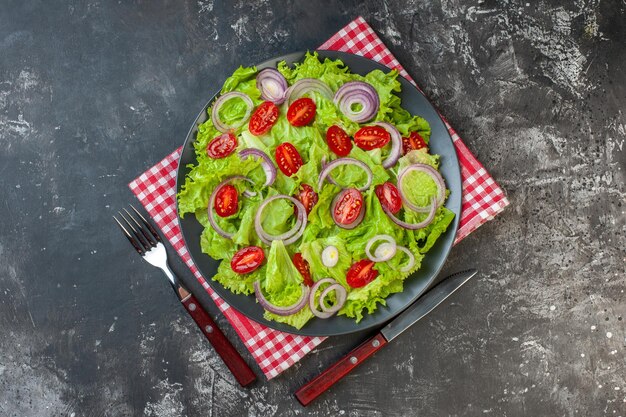 Draufsicht Frischgemüsesalat mit Zwiebeln grüner Salat und Tomaten auf grauem Hintergrund Gesundheit Foto Lebensmittelfarbe Diät Mahlzeit reifer Salat