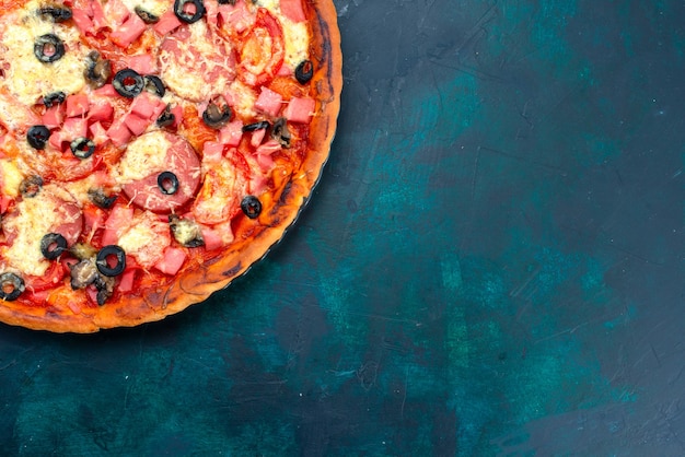 Draufsicht gebackene köstliche Pizza mit Olivenwürsten und Käse auf dem blauen Hintergrund.