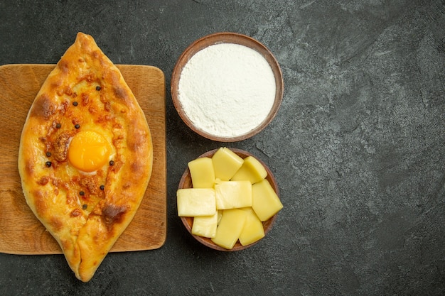 Draufsicht gebackenes Eierbrot köstliches Teigbrötchen frisch aus dem Ofen auf einem dunklen Schreibtisch