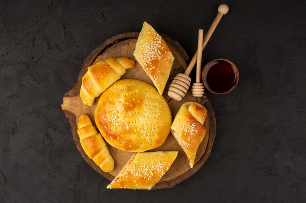 Draufsicht Gebäck und Croissants lecker lecker auf dem braunen Schreibtisch und dunkel