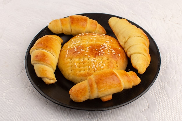 Draufsicht Gebäck und Croissants lecker lecker in schwarzer Platte auf dem weißen Boden