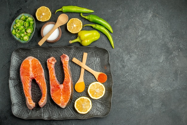 Draufsicht gebratene Fleischscheiben mit Paprika und Zitrone auf dunklem Hintergrund