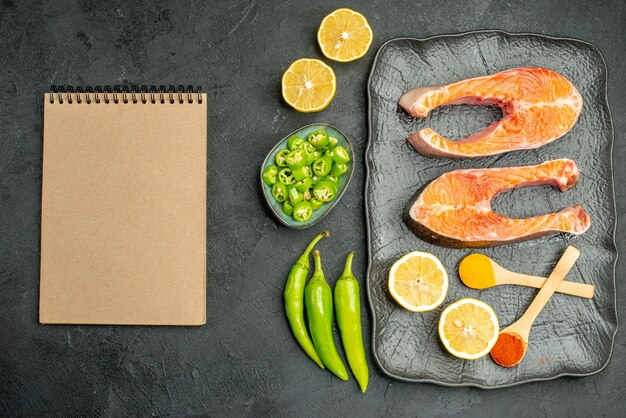 Draufsicht gebratene Fleischscheiben mit Paprika und Zitrone auf dunklem Hintergrund