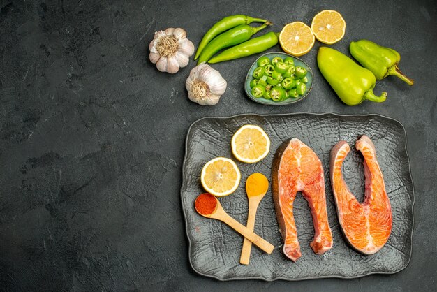 Draufsicht gebratene Fleischscheiben mit Paprika und Zitrone auf dunklem Hintergrund