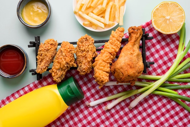 Draufsicht gebratene Hühnchenstücke auf Tablett mit Pommes und Saucen