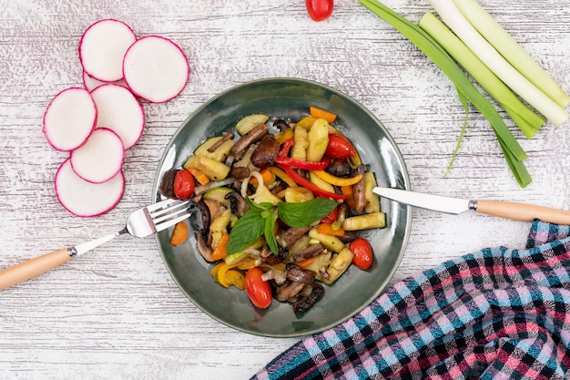 Draufsicht gebratener gelber Pfeffer des Gemüsesalatpilzkirschtomaten-roten Pfeffers mit Messer und Gabel