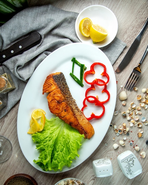 Draufsicht gebratener roter Fisch mit Paprika eine Zitronenscheibe