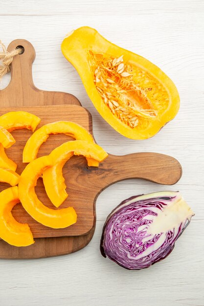 Draufsicht gehackter Butternut-Kürbis auf Schneidebrettern geschnittener Rotkohl und Butternut-Kürbis auf grauem Tisch