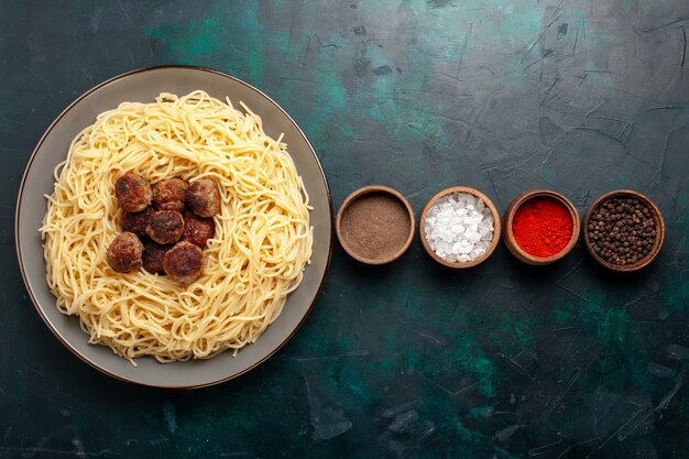 Draufsicht gekochte italienische Nudeln mit Fleischbällchen und Gewürzen auf der dunkelblauen Oberfläche