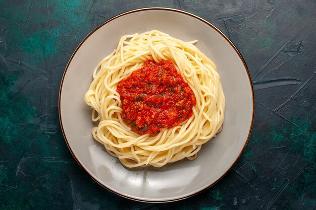 Draufsicht gekochte italienische Nudeln mit Hackfleisch und Tomatensauce auf der dunkelblauen Oberfläche