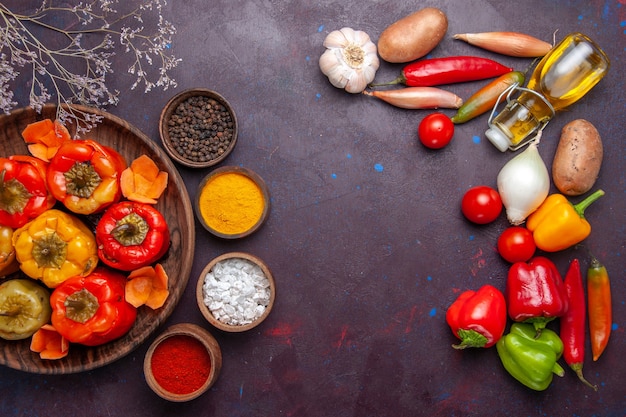 Draufsicht gekochte Paprika mit frischem Gemüse auf dem dunkelgrauen Oberflächenmehl Gemüsefleisch Dolma Essen