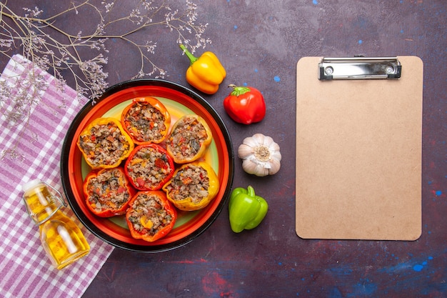 Draufsicht gekochte Paprika mit Hackfleisch und Notizblock auf einer dunklen Oberfläche Mahlzeit Gemüse Lebensmittel Fleisch Dolma