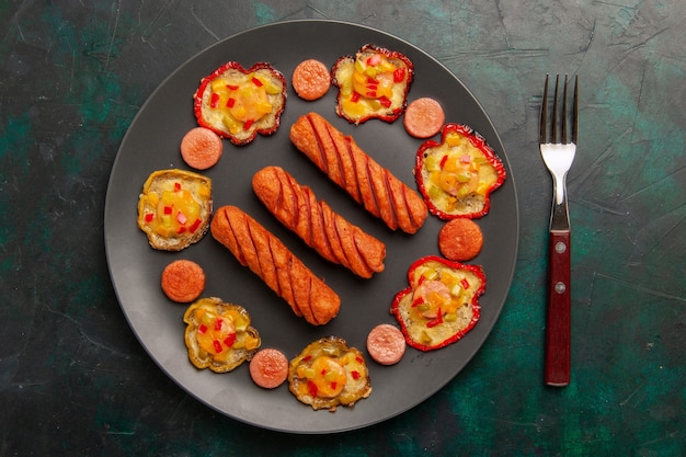 Draufsicht gekochte Paprika mit Würstchen auf dunkelgrüner Oberfläche