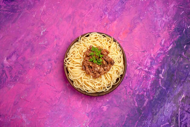 Draufsicht gekochte Spaghetti mit Hackfleisch auf dem rosafarbenen Tafelteigmahlzeit-Nudelgericht