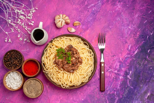 Draufsicht gekochte Spaghetti mit Hackfleisch auf rosa Tischgewürzgericht Teignudeln