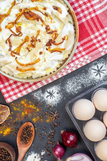 Draufsicht gekochte Teigstücke mit gebratenen Zwiebeln und verschiedenen Zutaten auf dunklem Hintergrund Gericht Essen Öl Mahlzeit Kochen Foto