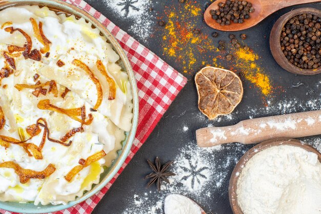 Draufsicht gekochte Teigstücke mit gebratenen Zwiebeln und verschiedenen Zutaten auf dunklem Hintergrund Gericht kochen Mahlzeit Abendessen Foto Essen