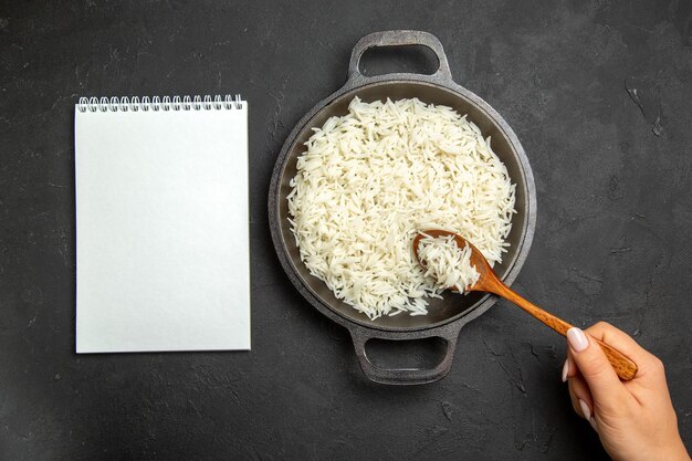 Draufsicht gekochter Reis in der Pfanne auf der dunklen Oberfläche Mahlzeit Reis östliches Abendessen