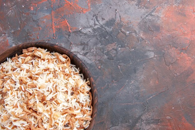 Draufsicht gekochter Reis mit Teigscheiben auf dunklem Bodenschalenmahlzeitnudeln mit dunklem Essen