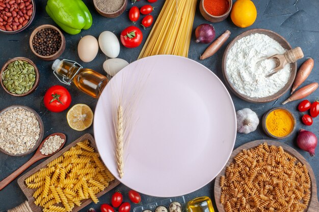 Draufsicht gekochter Teig mit rohen Nudelgemüsegewürzen und Eiern auf der dunklen Tischfarbe Ölkaloriennahrungsmittelei-Milchteig-Abendessenmahlzeit