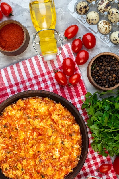 Kostenloses Foto draufsicht gekochtes frühstück spiegeleier und tomaten mit verschiedenen zutaten auf hellem hintergrund farbe morgenessen brot familienessen mittagessen