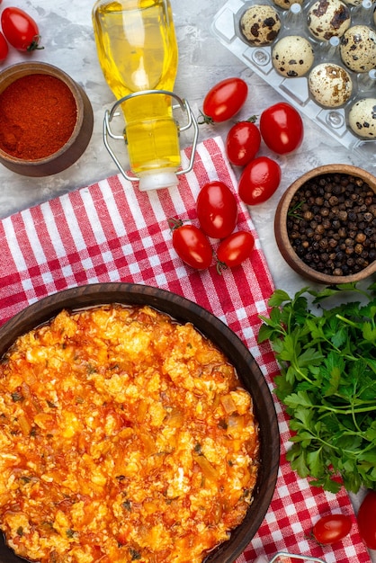 Draufsicht gekochtes Frühstück Spiegeleier und Tomaten mit verschiedenen Zutaten auf hellem Hintergrund Farbe Morgenessen Brot Familienessen Mittagessen