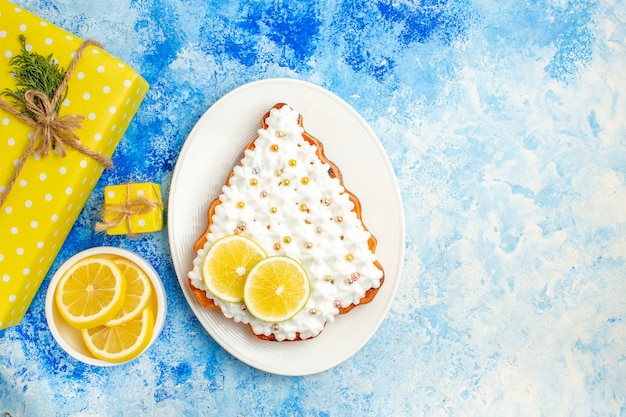 Draufsicht gelber Geschenkzitronenscheibenkuchen auf Teller auf blauem Tischfreiraum