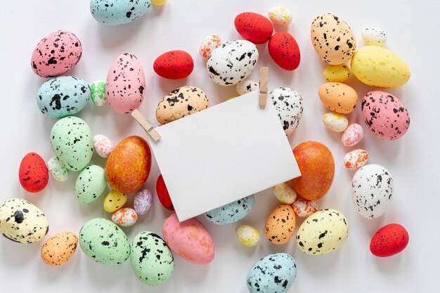 Draufsicht gemalte Eier mit Papierkarte