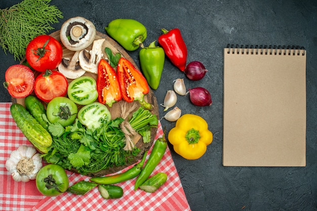 Draufsicht Gemüse Pilze Tomaten rote und grüne Paprika Grüns auf Holzbrett