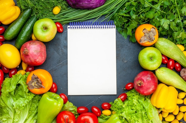 Draufsicht Gemüse und Obst Salat Tomaten Gurke Dill Kirsche Tomaten Zucchini Granatapfel Persimone Apfel Notizbuch in der Mitte