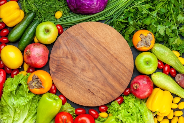 Draufsicht Gemüse und Obst Salat Tomaten Gurke Dill Kirschtomaten Zucchini Frühlingszwiebel Petersilie Granatapfel Persimone Apfel Runde Holzbrett in der Mitte