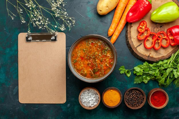 Draufsicht Gemüsesuppe mit frischem Gemüse und Gewürzen auf dunkelgrüner Oberfläche Zutat Mahlzeit Lebensmittel Gemüsesuppe