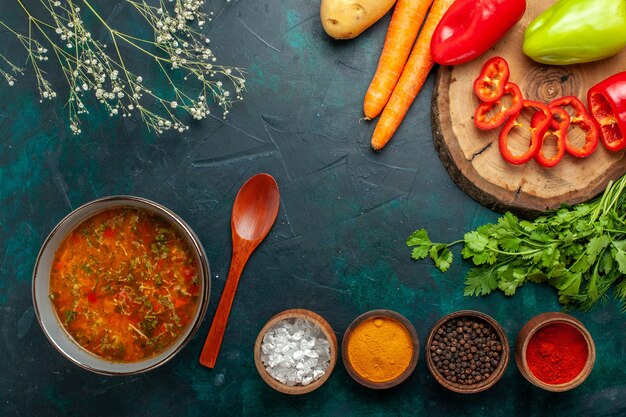 Draufsicht Gemüsesuppe mit frischem Gemüse und Gewürzen auf dunkelgrüner Oberfläche Zutat Suppe Mahlzeit Lebensmittel Gemüse