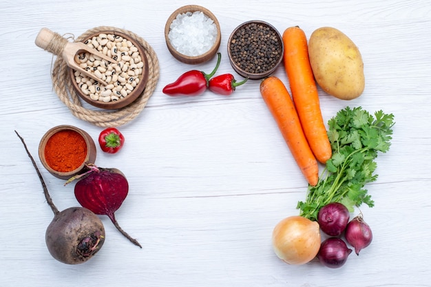 Kostenloses Foto draufsicht gemüsezusammensetzung mit frischem gemüse grün rohen bohnen karotten und kartoffeln auf dem leichten schreibtisch essen mahlzeit gemüsesalat